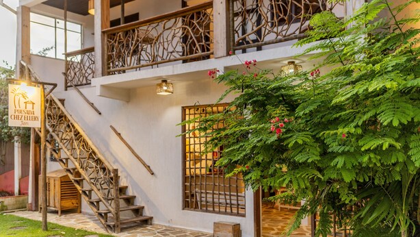 Een traditioneel gebouw met een houten trap, een balkon met decoratieve balustrade en een bord dat een restaurant aangeeft.