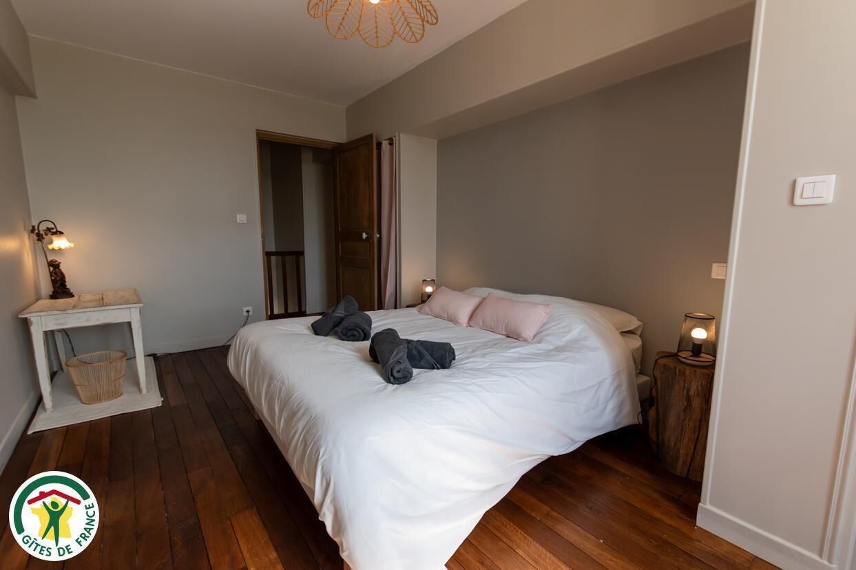 Een slaapkamer met een bed, nachtkastjes en een deur.