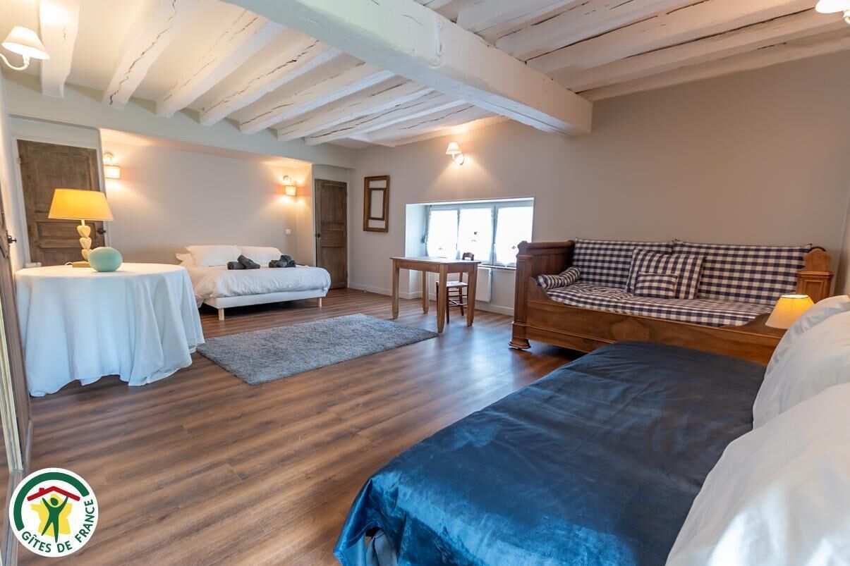 Ein Zimmer mit einem Bett, einem Sofa, einem Tisch und einer Lampe.