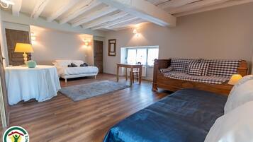 Ein Zimmer mit einem Bett, einem Sofa, einem Tisch und einer Lampe.