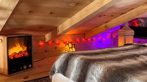Une pièce chaleureuse avec un lit, une cheminée et une lanterne décorative.