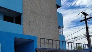 A multi-story building with a blue facade and a beige central section. - Edifício Flat Euro (Natal)