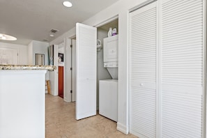 A laundry room with a washing machine, dryer, and storage cabinets.