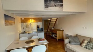 Ein kompakter Wohnbereich mit Essplatz, Küchenzeile und einer Couch.