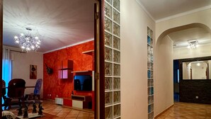 A spacious living area with a large open space, a fireplace, and a television. - Apartamento Mar Olhão | Spacious 2-Bedroom Apartment in Prime Location (Olhão)
