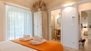 A hotel room with a bed, a bathroom, and a hallway.