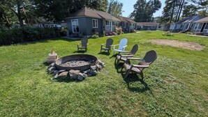 A backyard with a fire pit, outdoor seating, and a house. - Cottage #4 - Beautiful 3 Bedroom Lakefront Cottage - Fully Renovated in 2024! (Ashville)