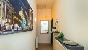 A hallway with a poster, a reception desk, and a door.