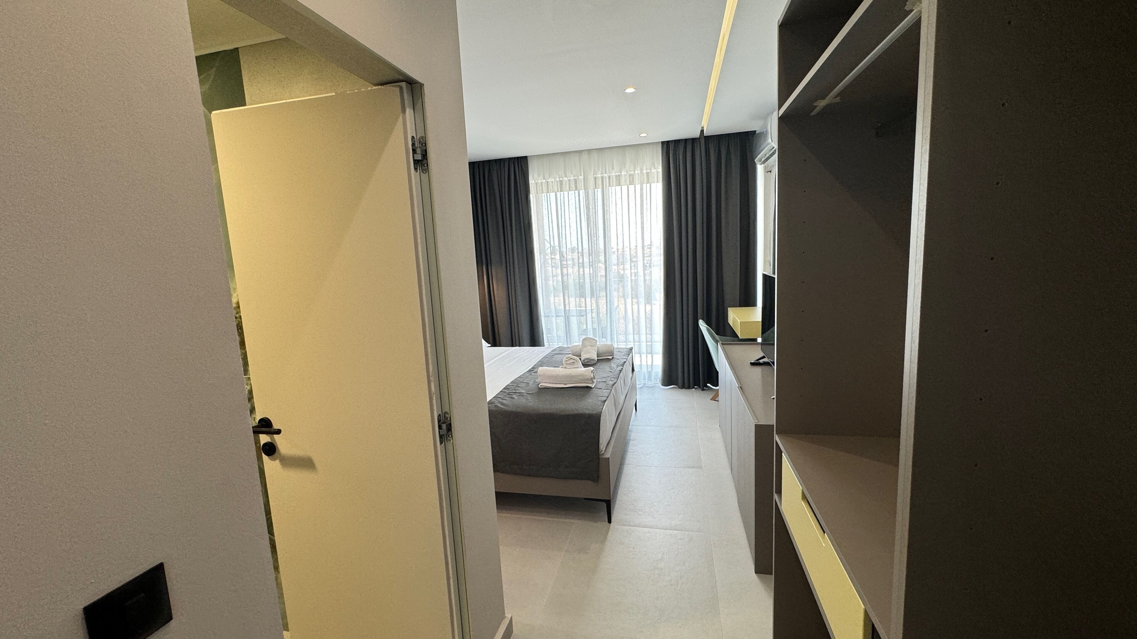 Une chambre d’hôtel moderne équipée d’un lit, d’un bureau et d’une armoire.