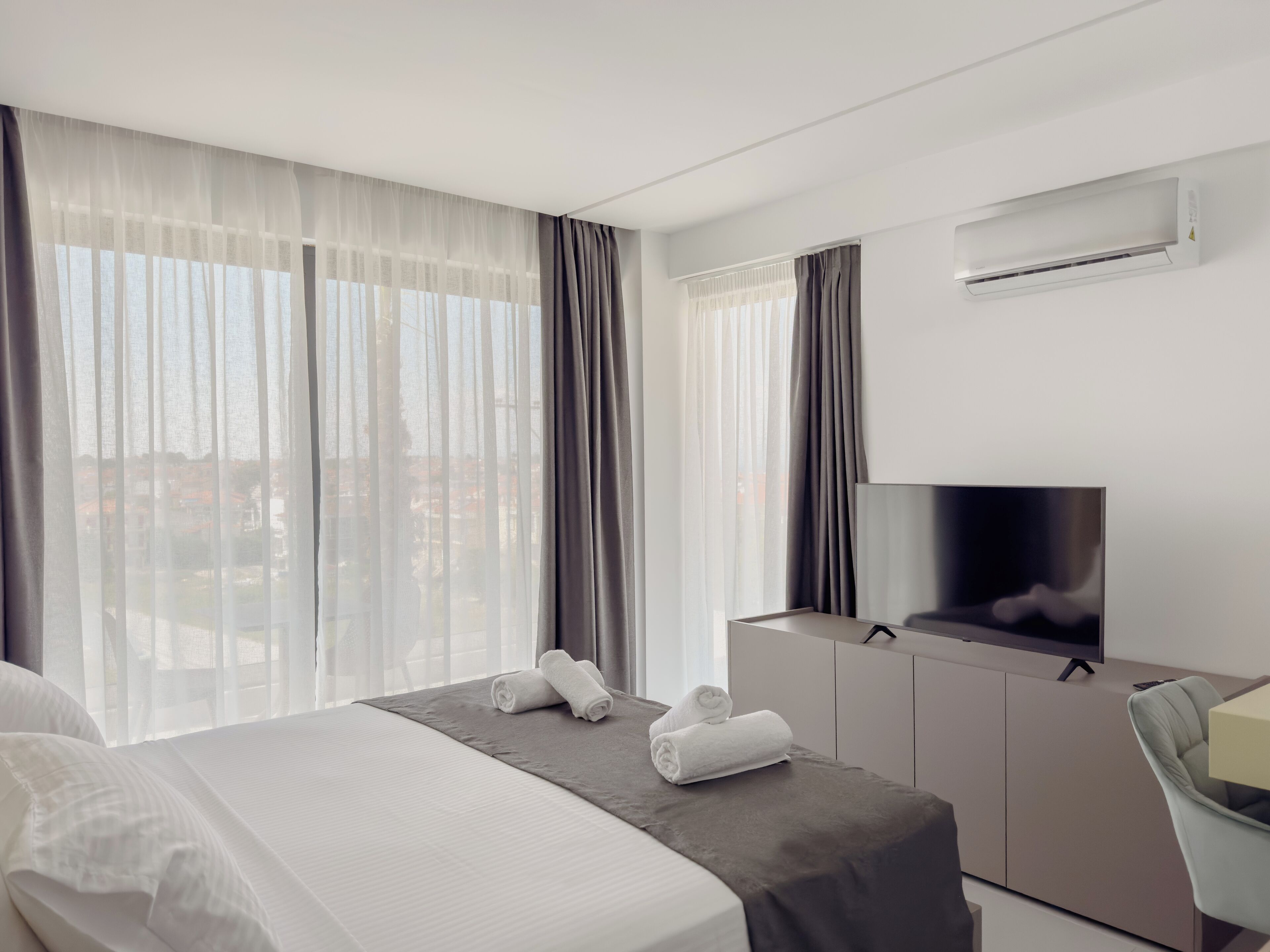 Een hotelkamer met een bed, een televisie en een bureau.