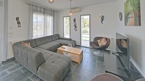 Una sala de estar moderna con un sofá seccional, una mesa de centro y un televisor de pantalla plana.