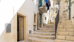 Eine enge Gasse mit Steinstufen, die zu einem Hauseingang führen.