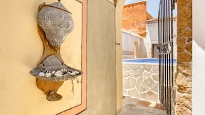 Ein Wandbild eines Fisches mit Ablagefläche, ein Metallgitter und eine Steinmauer.