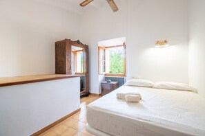 A bedroom with a bed, a wooden dresser, a window, and a radiator. - Holiday Home 'Ca'n Repic' with Mountain View, Private Terrace and Wi-Fi (Illes Balears)