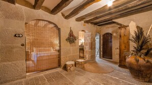 A stone-walled interior with a wooden door, a small bench, and a large potted plant. - Stone House with Private Spa and Unique Jacuzzi (Nalec)
