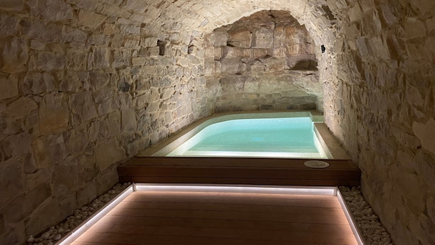 A stone-walled spa area with a wooden deck leading to a pool. - Stone House with Private Spa and Unique Jacuzzi (Nalec)
