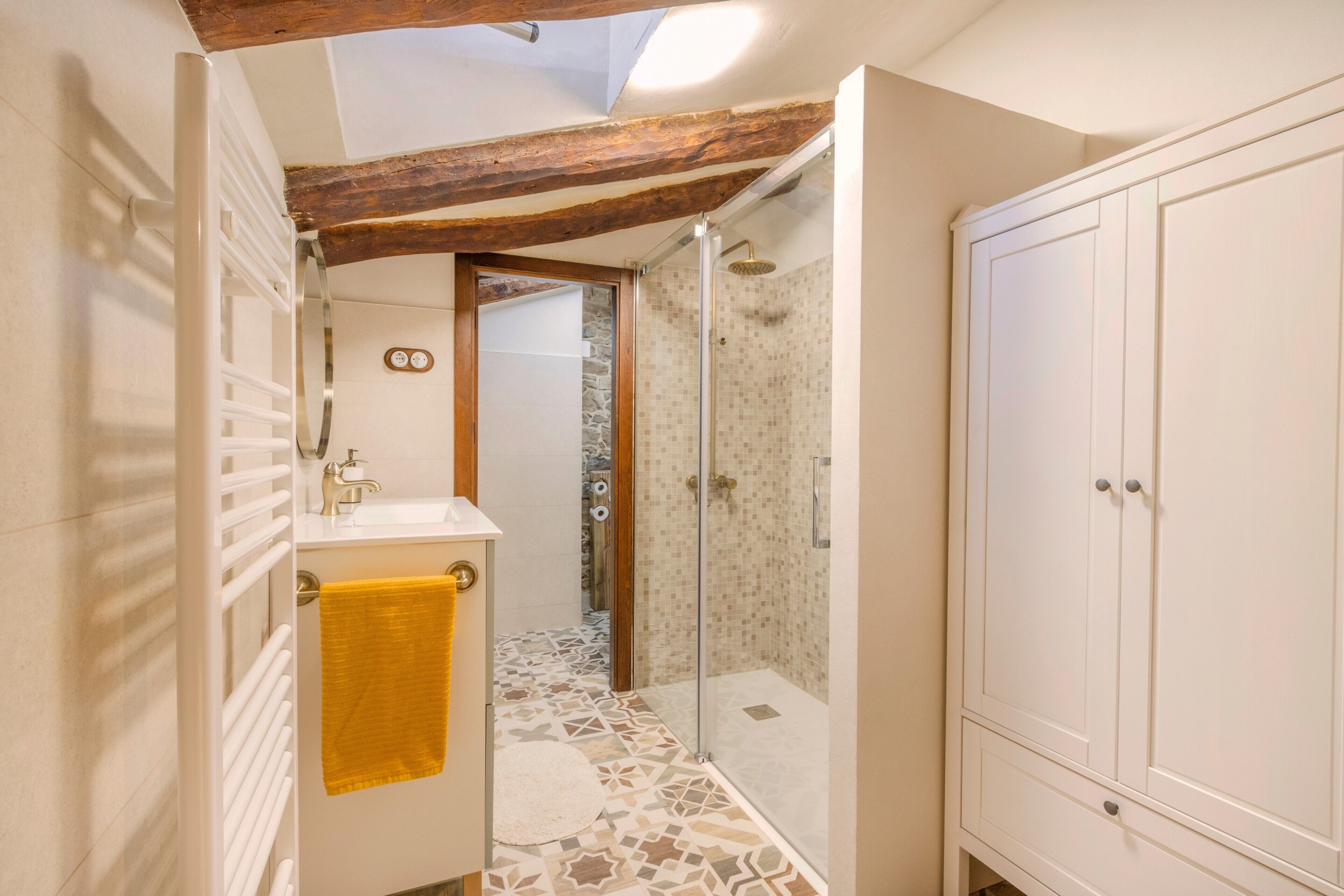 A bathroom with a shower, a toilet, a sink, and a cabinet.