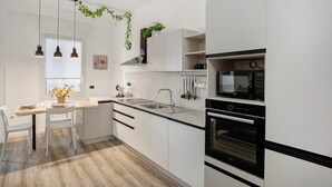 Eine moderne Küche mit weißen Schränken, einem eingebauten Backofen, einer Mikrowelle und einem Fenster mit Blick.