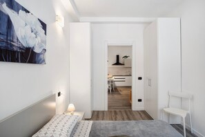 Une chambre à coucher moderne avec un lit, une table de chevet et un tableau au mur.