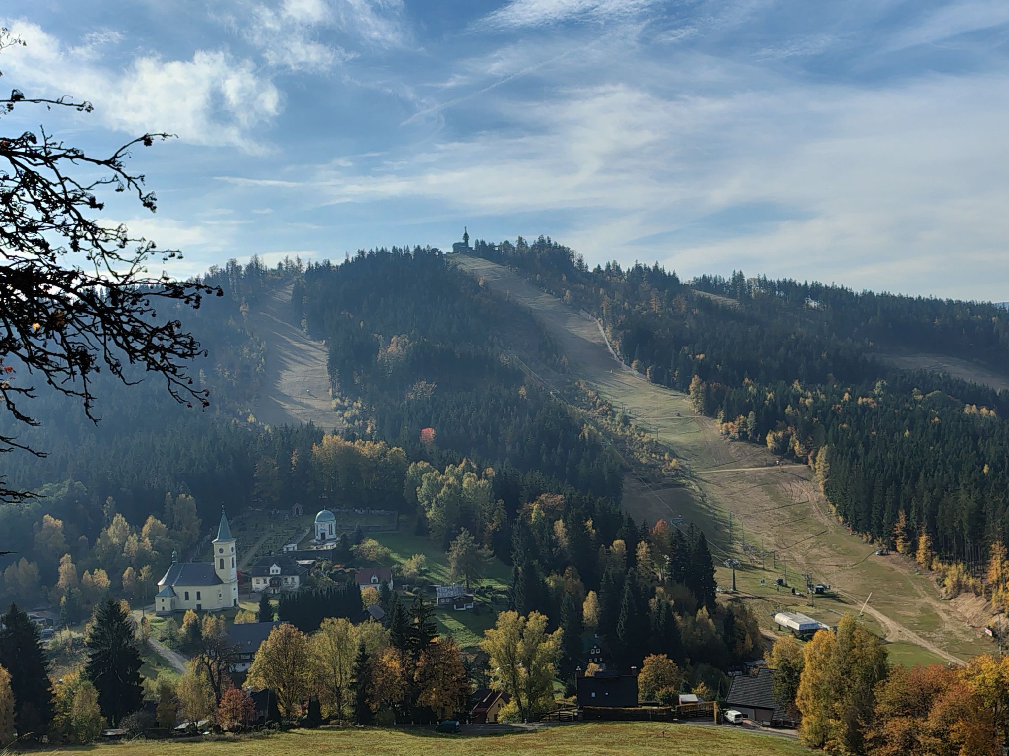 A mountainous landscape with a church and residential buildings.