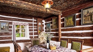 A rustic wooden room with a wooden bed, a wooden table, and a window with curtains. - Jizerka by Interhome (Tanvald)