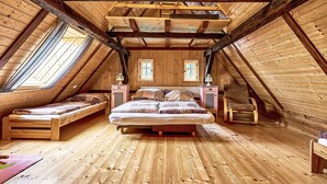 A cozy attic bedroom with a loft bed, two smaller beds, a chair, and a dresser. - Jizerka by Interhome (Tanvald)