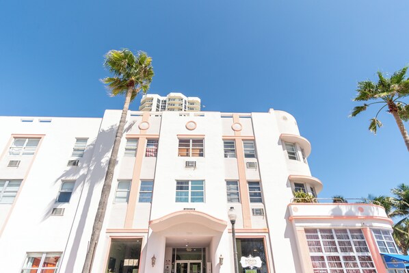 A multi-story hotel with a classic architectural design, featuring a central entrance with a canopy, multiple windows, and balconies.