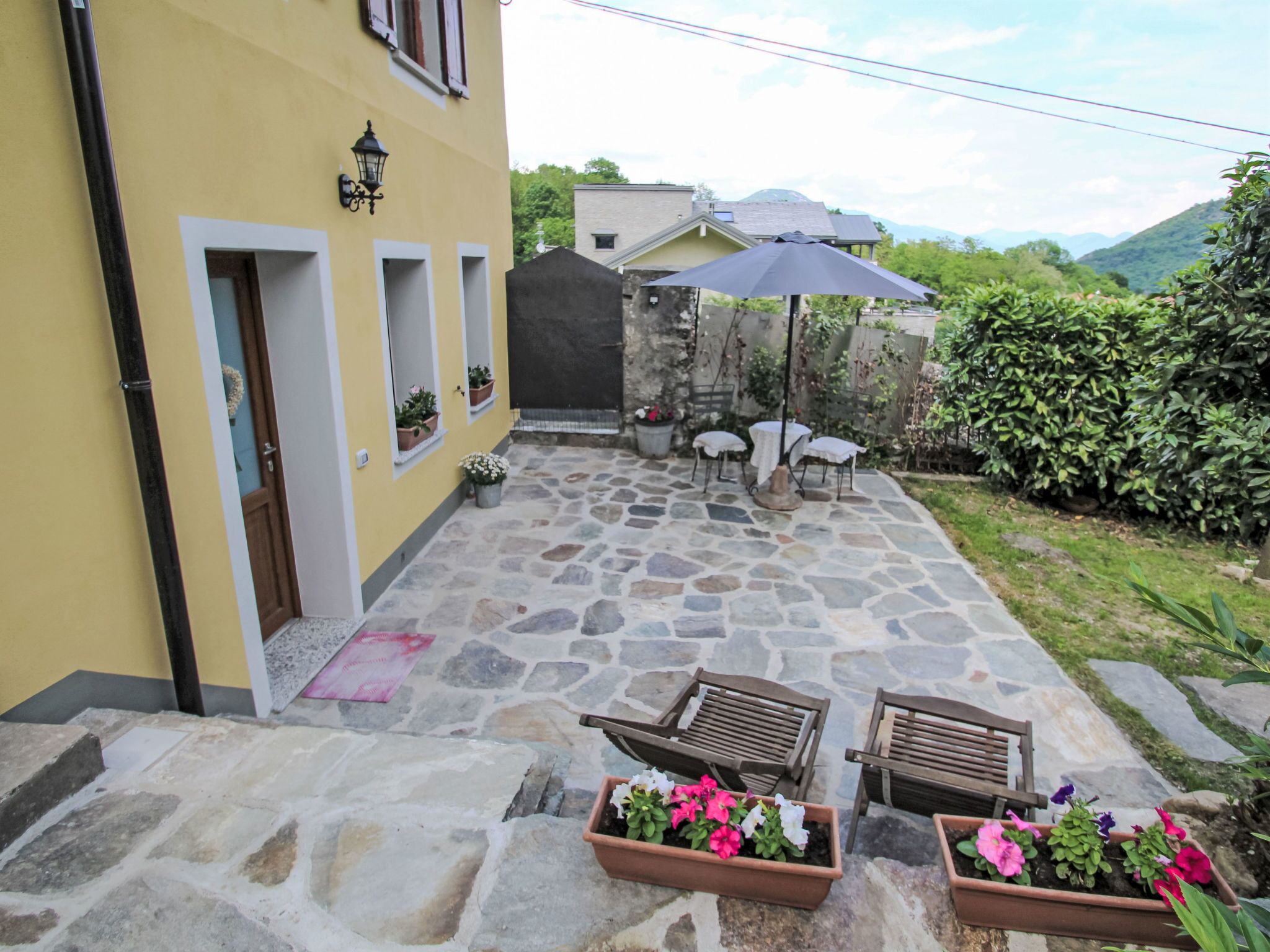 A stone patio with outdoor seating and potted plants.