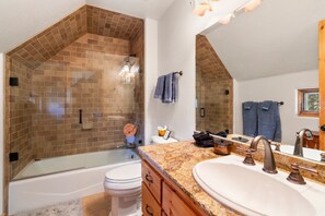 A bathroom with a glass-enclosed shower, a bathtub, a large mirror, and a granite countertop. - A/C, Views, Newly Renovated, Peaceful Retreat! (Durango)