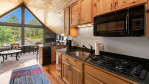 A modern kitchen with wooden cabinets, a stainless steel sink, a black stove, and a built-in microwave. - A/C, Views, Newly Renovated, Peaceful Retreat! (Durango)
