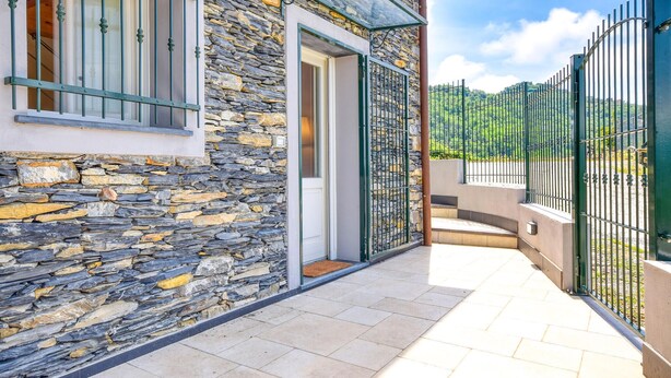A stone building with a metal gate and a clear sky.
