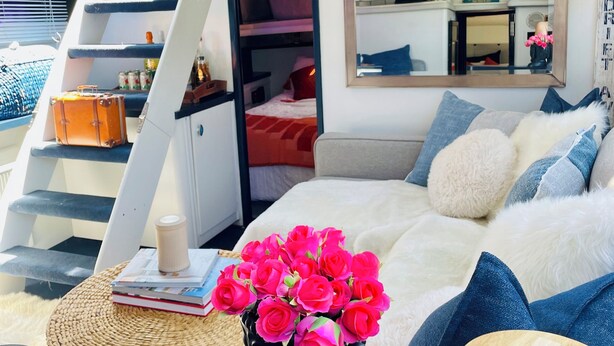 A modern bedroom with a bunk bed, a bedside table with a vase of flowers, a mirror, and a staircase. - Floating 2 bed 2 bath condo stunning views of the bay  (Stevensville)