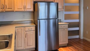 A kitchen with wooden cabinets, a stainless steel refrigerator, and a wooden floor. - Oceanfront🔹Abundant Wildlife Viewing Opportunities🔹Local Native Owners (Ketchikan)