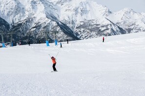 A snowy ski slope with skiers and a mountain backdrop. - Starkeeper Apartment Ski Base with Balcony Views, Pragelato, Italy (Pragelato)