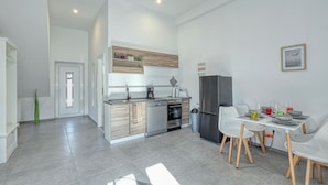 Eine moderne Küche mit Essbereich, inklusive Kühlschrank, Backofen und Spüle.