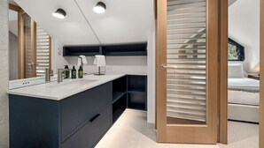 Une salle de bain moderne avec un grand miroir, un lavabo et un espace douche.