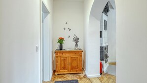 A hallway with a wooden cabinet, a vase with flowers, and wall decals. - 3 bedroom cozy apartment in Großenbrode (Großenbrode)
