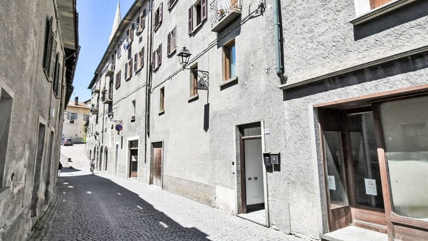 A narrow cobblestone street lined with historic buildings, featuring a mix of residential and commercial properties. - Erica Apartment by Interhome (Bormio)