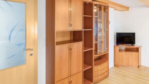 A room with a wooden wardrobe, a television, and a door with a frosted glass panel. - Awesome home in Wies with WiFi (Wies)