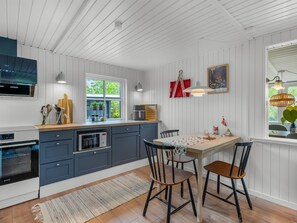 Una cocina con microondas, estufa y armarios de madera.