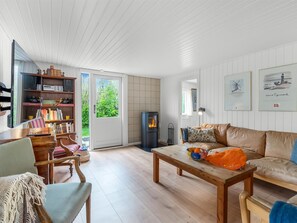 Una sala de estar con chimenea, estantería, sofá y mesa de comedor.