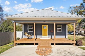 A house with a covered porch, a swing, and a brick pathway leading to the front door. - Updated 2 Floor Central Downtown Raleigh Home (Raleigh)