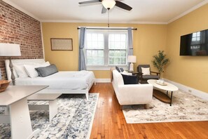 Relax in a stylish room with a large bed, sofa, and flat-screen TV.