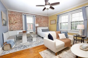 Relax in a classic guest room with a comfortable bed, armchair, and sofa, plus a desk and table for work and relaxation.