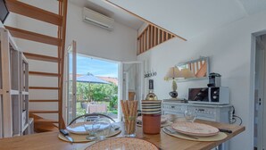 Une cuisine moderne avec un plan de travail en bois, une table à manger dressée avec des assiettes et des couverts, une bouteille de vin et un four à micro-ondes.