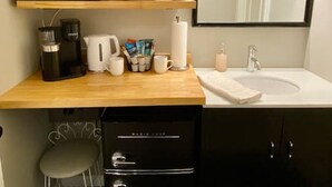 A compact, modern bathroom with a wooden countertop, a sink, a mirror, and a black cabinet. - Downtown+FreePark+Wifi Main St. Ste 201 (Eureka Springs)