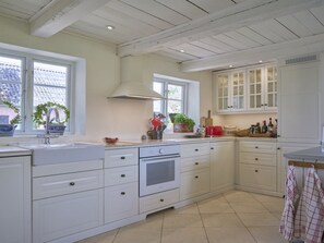 Een koelkast, een vaatwasser, kookgerei, borden en bestek