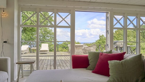 Un dormitorio con un ventanal grande, una cama y vistas al exterior.