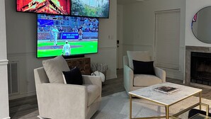 A living room with a sofa, armchair, coffee table, and a fireplace. - Freshly renovated condo in the heart of College Station! Sleeps 6 (College Station)