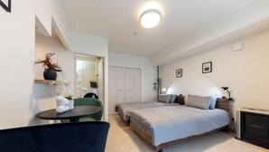 A modern bedroom with a bed, bedside table, and a chair. - HILLS SAPPORO 203 (Sapporo)